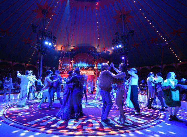 Tanzende Menschen in einer Zirkusmanege