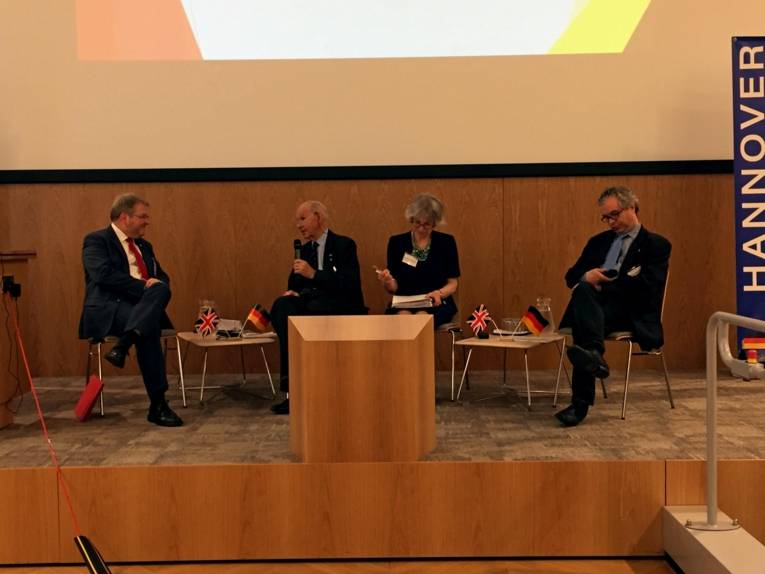 Drei Männer und eine Frau auf einer Bühne. 