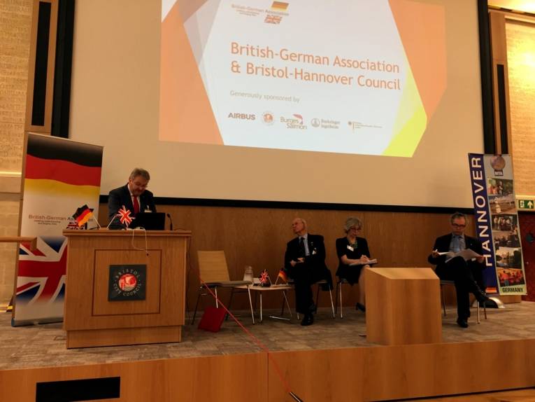 Drei Männer und eine Frau auf einer Bühne. 