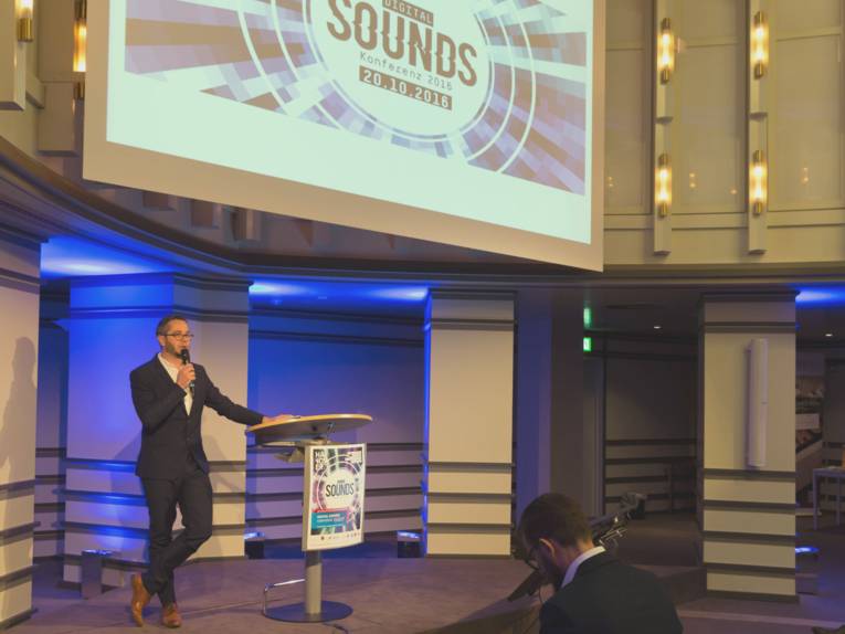 Ein Mann steht auf der Bühne der Fachkonferenz "Digital Sounds 2016" und spricht in ein Mikrofon.