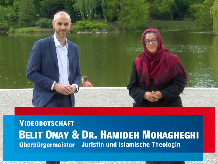 Screenshot eines Videos, in dem ein Mann und eine Frau vor einem Teich zu sehen sind. 