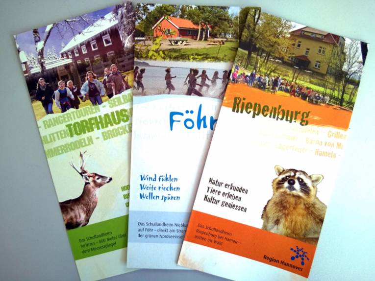 Drei Flyer aufgefächert nebeneinander.