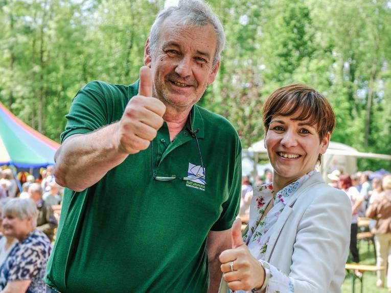 Ein Mann und eine Frau stehen nebeneinander und recken beide den ausgestreckten Daumen in die Luft.