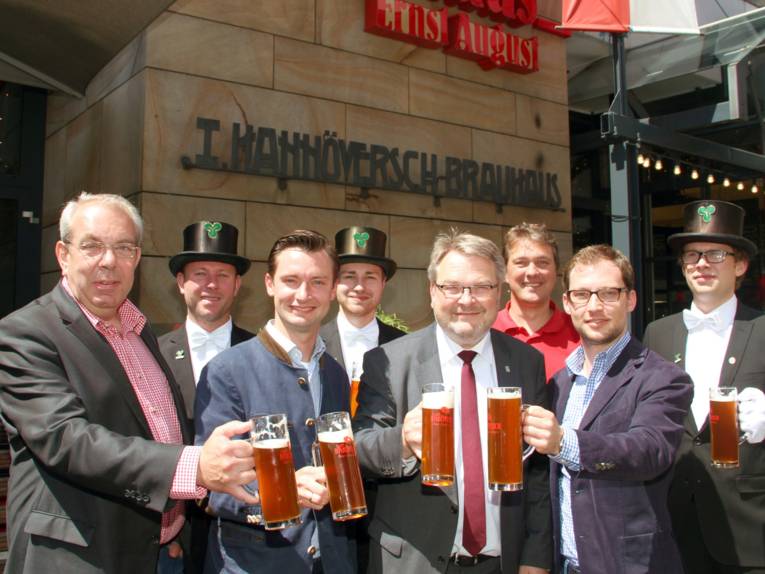 Acht Männer mit Biergläsern.