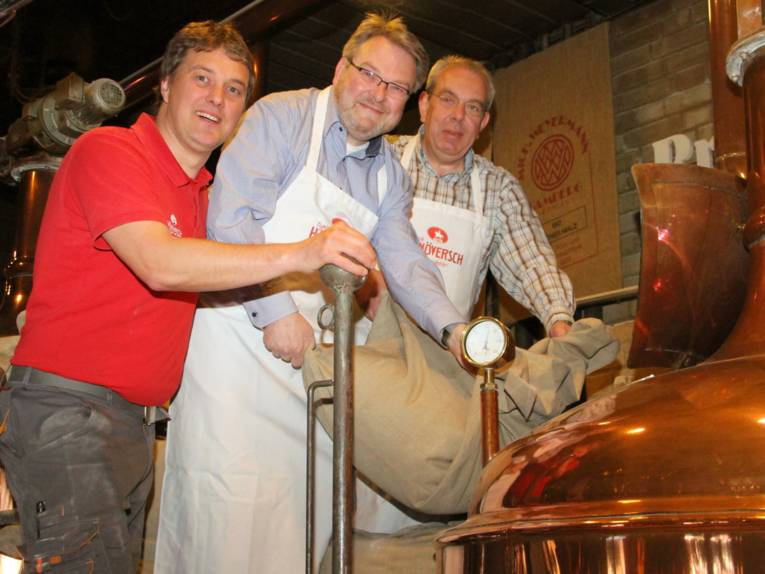 Drei Männer an einem Kessel. 