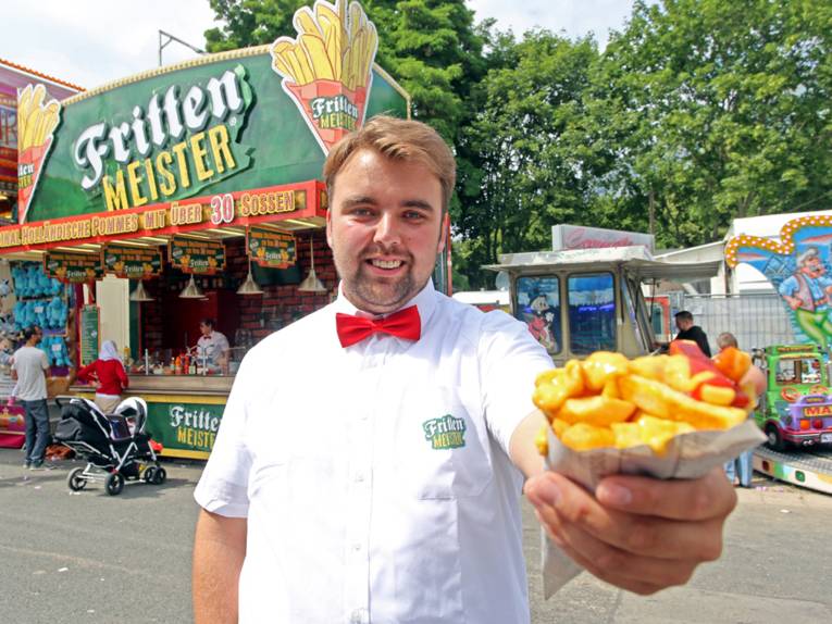 Mann mit einer Tüte Pommes frites. 