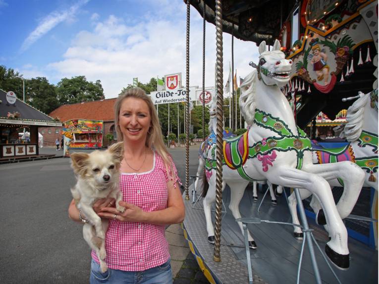 Frau mit Hund an einem Etagenkarussell. 