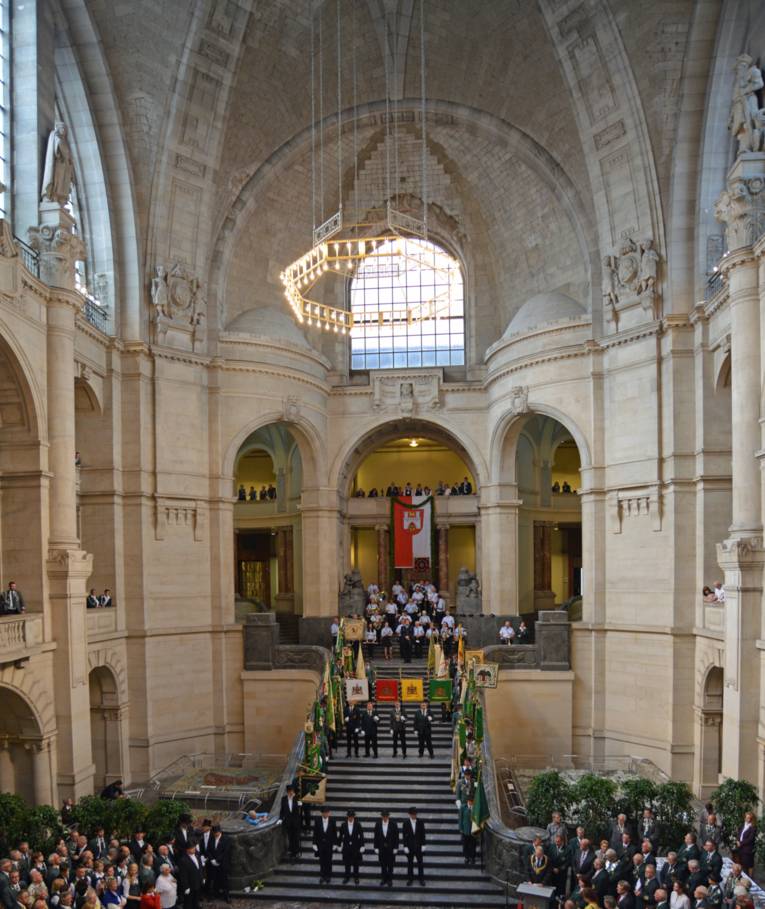 Blick auf eine imposante Treppe in einer großen Halle mit Menschen.