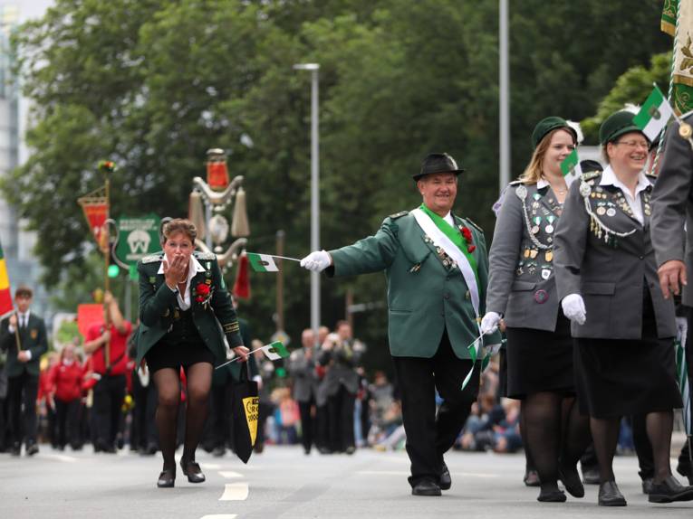 Treiben bei einem Festumzug und auf einem Platz. 