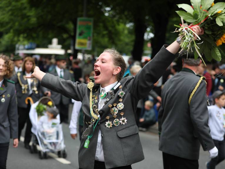 Treiben bei einem Festumzug und auf einem Platz. 