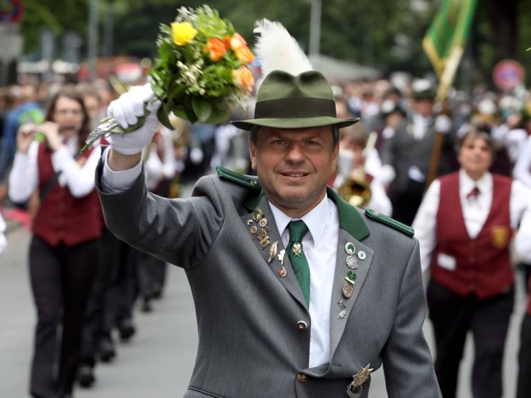 Treiben bei einem Festumzug und auf einem Platz. 