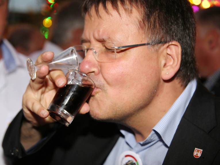 Männer in Cut und Zylinder auf einem Festplatz und in einem Zelt. 