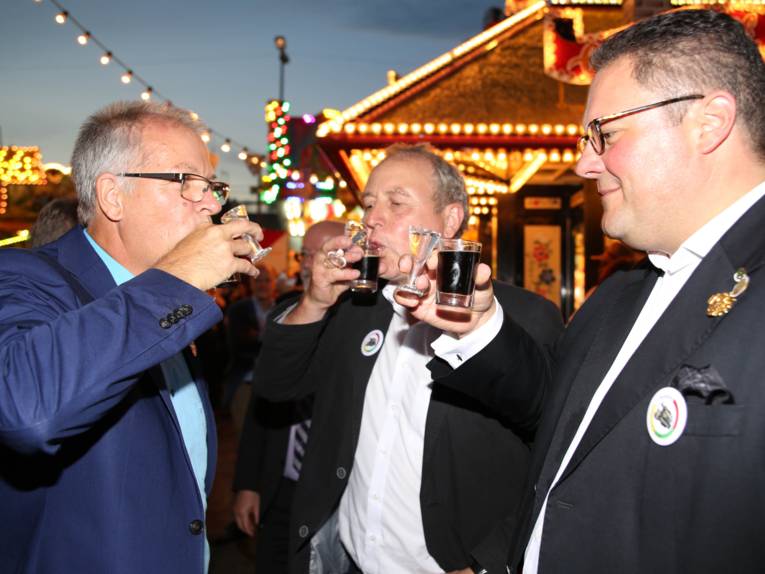 Männer in Cut und Zylinder auf einem Festplatz und in einem Zelt. 