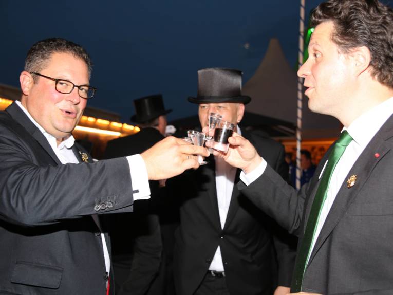 Männer in Cut und Zylinder auf einem Festplatz und in einem Zelt. 