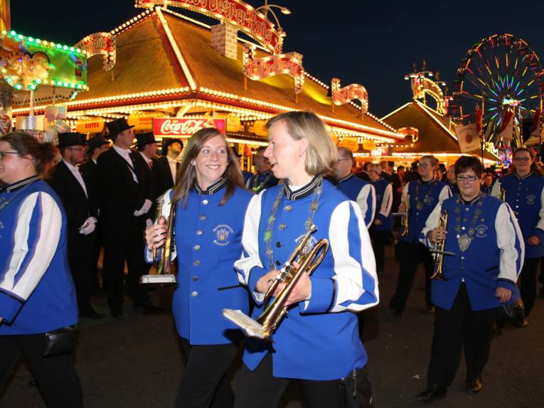 Männer in Cut und Zylinder auf einem Festplatz und in einem Zelt. 