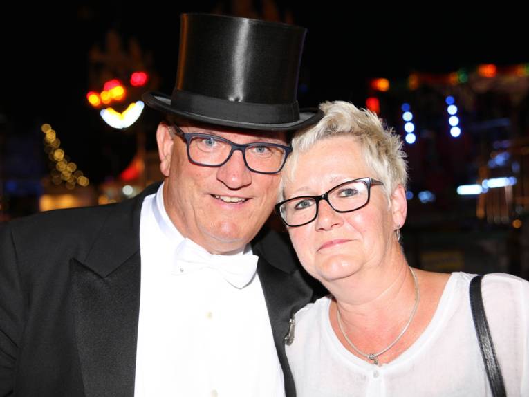 Männer in Cut und Zylinder auf einem Festplatz und in einem Zelt. 