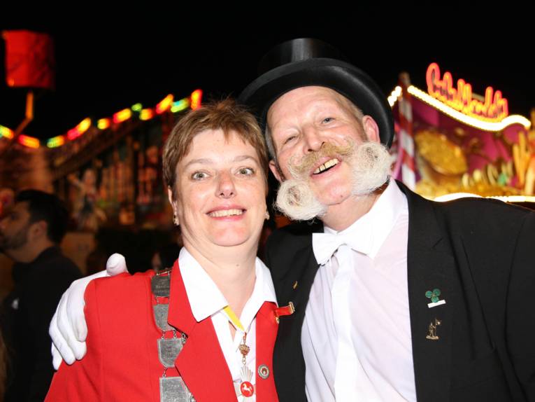 Männer in Cut und Zylinder auf einem Festplatz und in einem Zelt. 