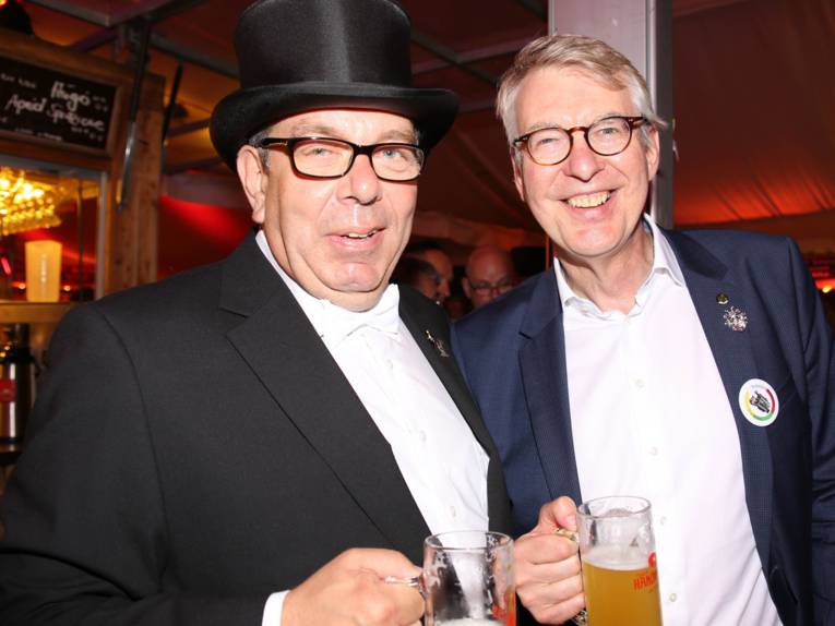 Männer in Cut und Zylinder auf einem Festplatz und in einem Zelt. 