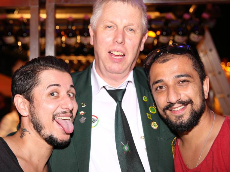 Männer in Cut und Zylinder auf einem Festplatz und in einem Zelt. 