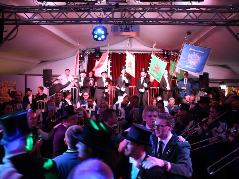 Männer in Cut und Zylinder auf einem Festplatz und in einem Zelt. 