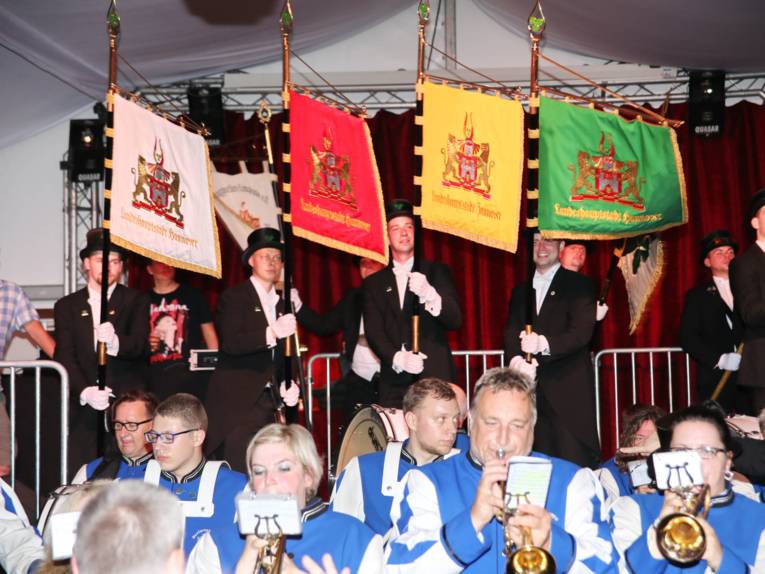 Männer in Cut und Zylinder auf einem Festplatz und in einem Zelt. 