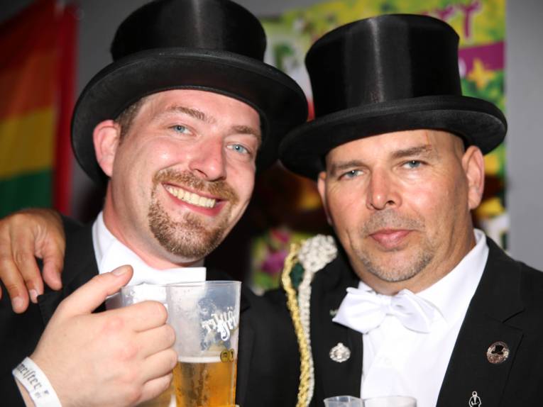 Männer in Cut und Zylinder auf einem Festplatz und in einem Zelt. 