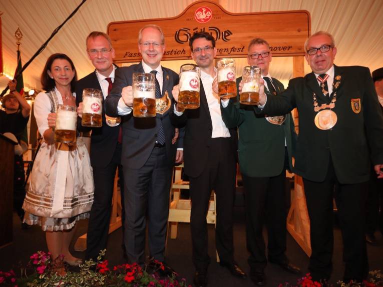 Eine Frau und fünf Männer mit Biergläsern. 