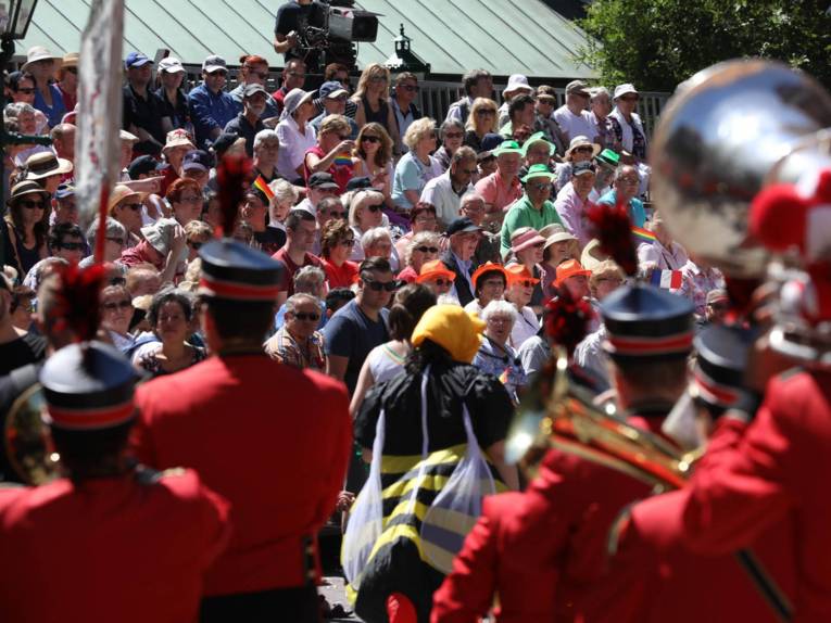 Menschen auf einer Tribüne. 