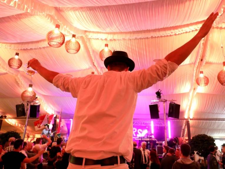 Mann in einer Festhalle.