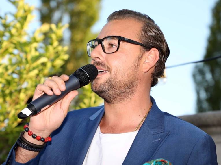 Mann an einem Mikrofon. 