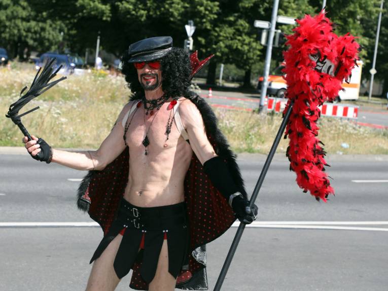 Als Teufel verkleideter Mann auf einer Straße. 