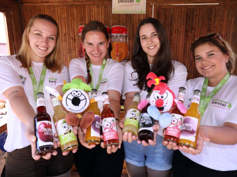 Vier junge Frauen, die verschiedene Flaschen präsentieren. 
