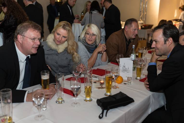 Menschen bei einer Feier in einem Gewölbe. 