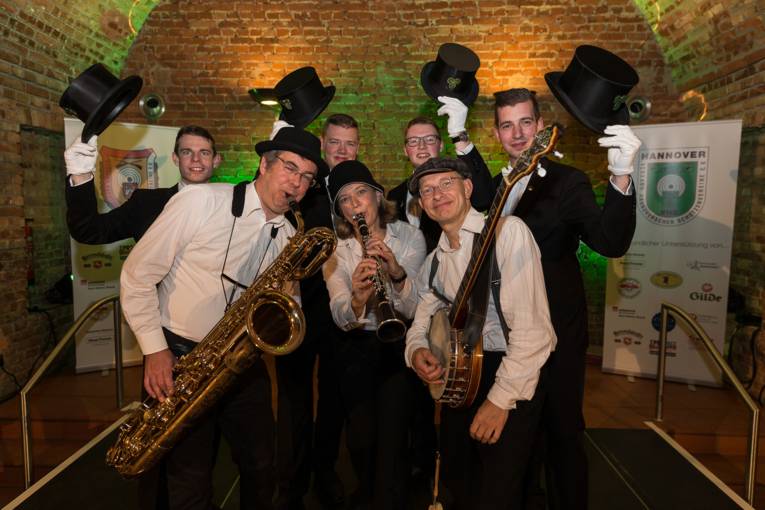 Menschen bei einer Feier in einem Gewölbe. 