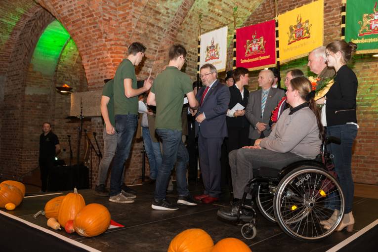 Menschen bei einer Feier in einem Gewölbe. 