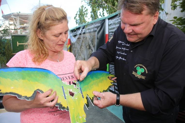 Menschen an einem Schießstand und in einer Festhalle. 