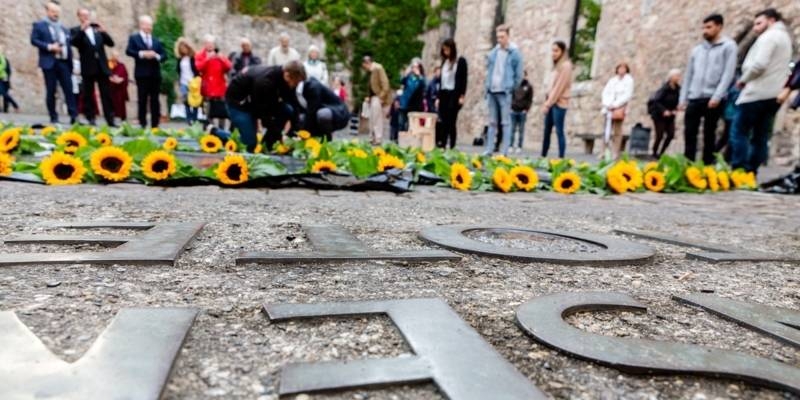 Junge Leute legen Sonnenblumen zum Gedenken an die Verstorbenen nieder.