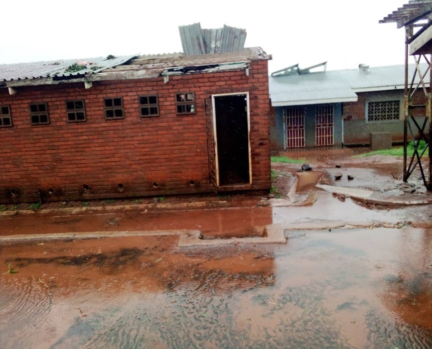 An einem Gebäude einer Primary School in Blantyre ist das Dach stark beschädigt. Das Gelände selber steht unter Wasser.